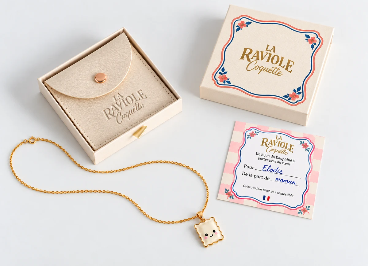 La boîte Raviole Coquette avec sa pochette beige à bouton pression, le collier et une carte personnalisée
